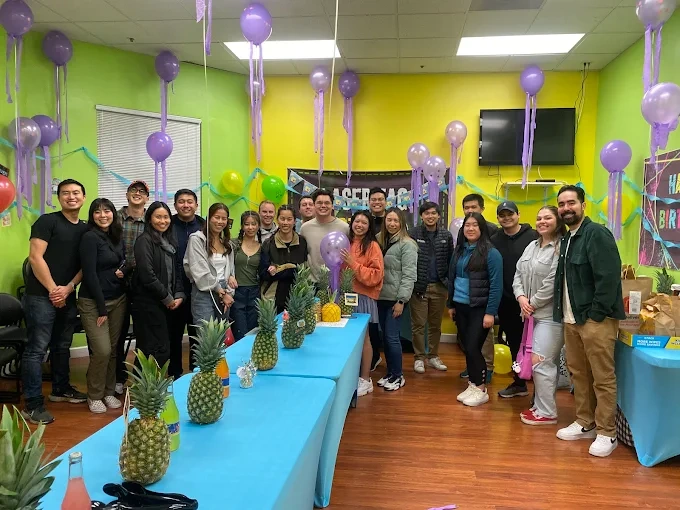 Group celebrating a birthday party with balloons and decorations
