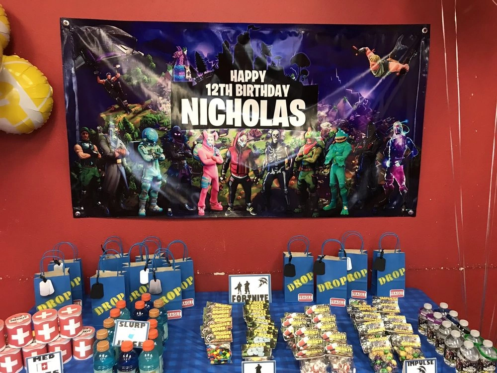 Fortnite-themed 12th birthday party with banner and party favors