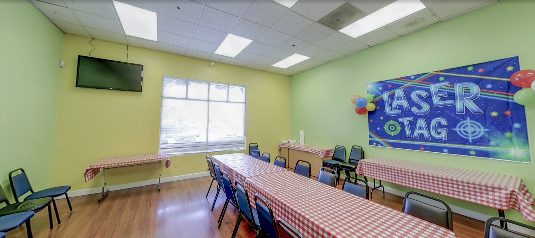 Party room with checkered tables and balloon decorations